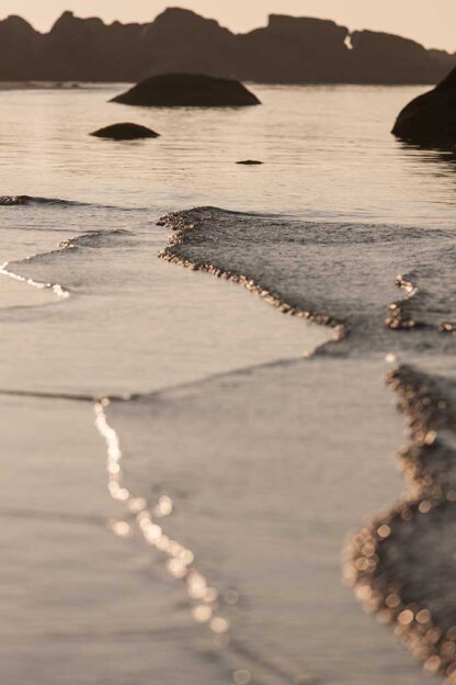 Strand und Wellen im Gegenlicht