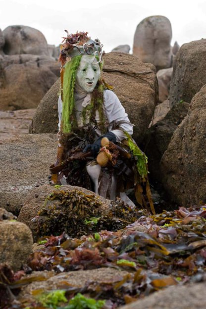 Maskenspiel am Strand mit Algen in der Bretagne