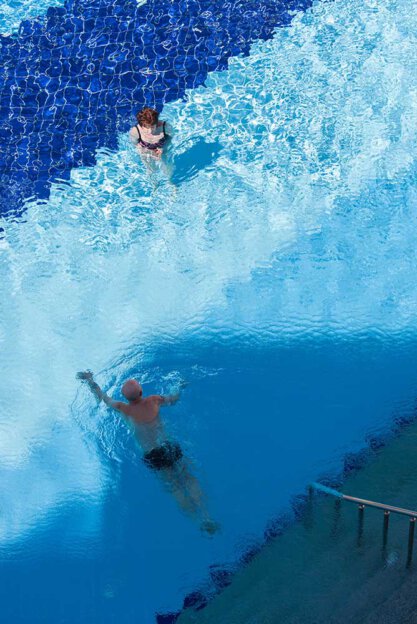 Frau und Mann schwimmen am Pool