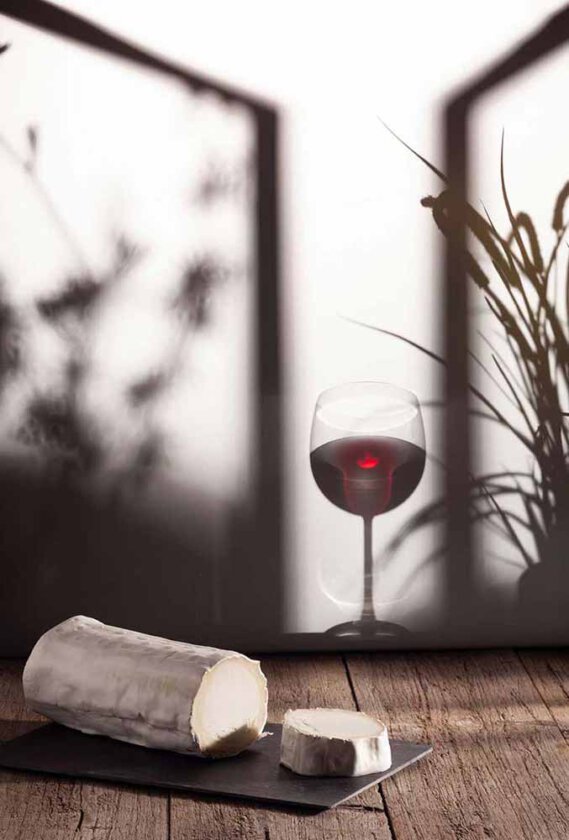 Rotwein Glass mit Ziegenkäse und Schatten im Hintergrund